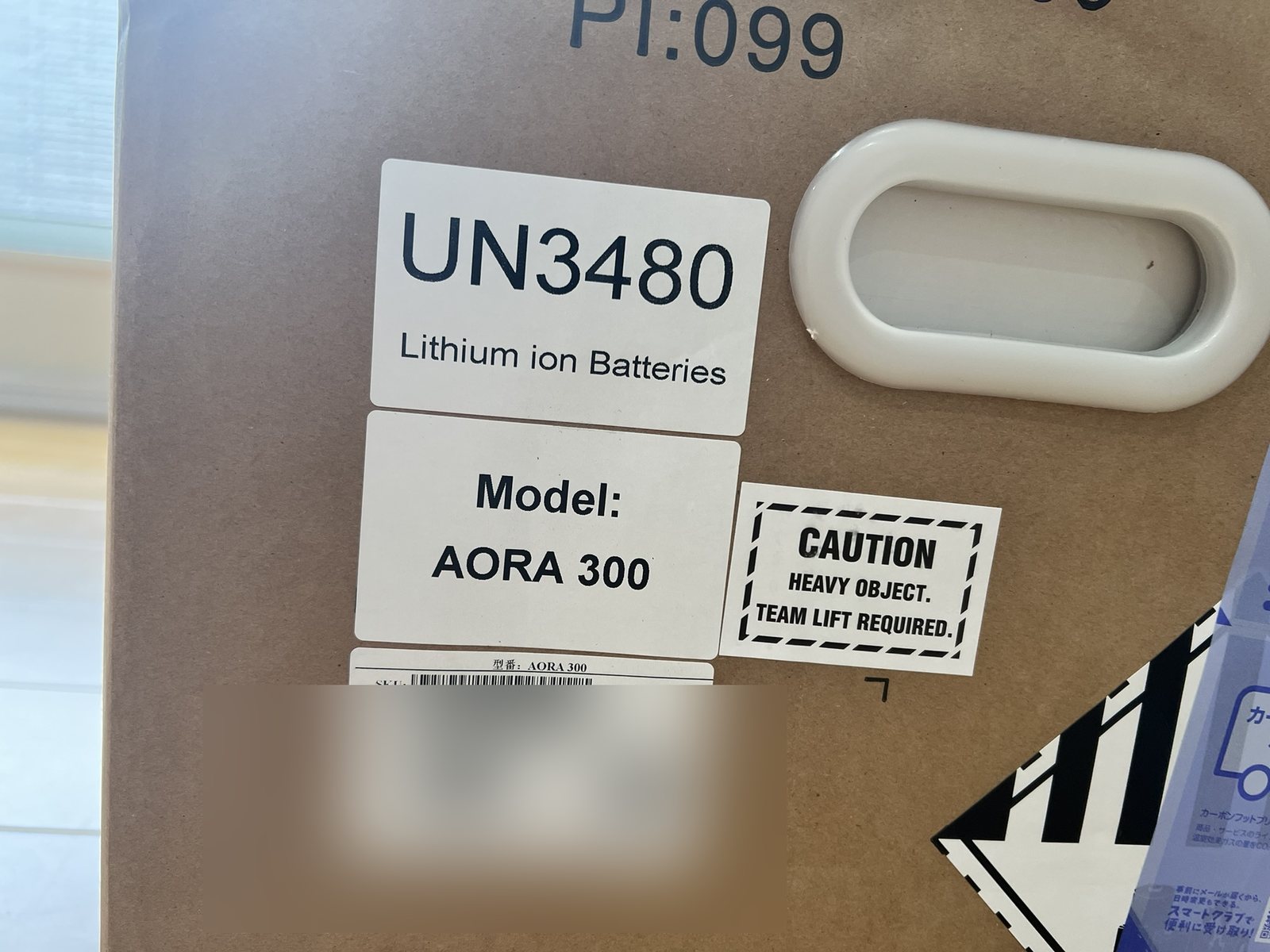 AORA 300の外箱に貼られたCAUTION HEAVY OBJECT / TEAM LIFT REQUIREDの警告ラベル