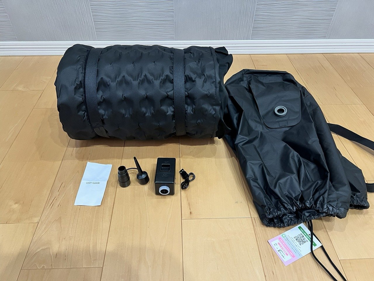 Relaxing CampMat PLUSのセット内容。丸めたマット本体・収納袋・電動ポンプ・ノズル・説明書